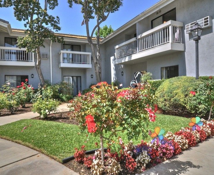 A well-maintained apartment building with a colorful garden.