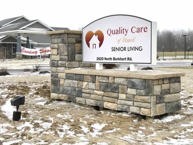 A sign for Quality Care Senior Living located in a snowy outdoor setting.