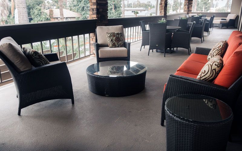 Outdoor patio seating area with comfortable furniture and a glass-top table.