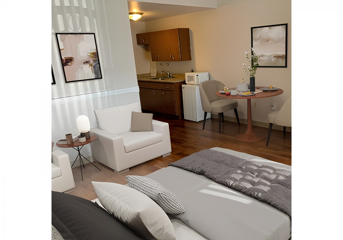A modern studio apartment featuring a cozy living area, comfortable bed, and a small kitchenette.