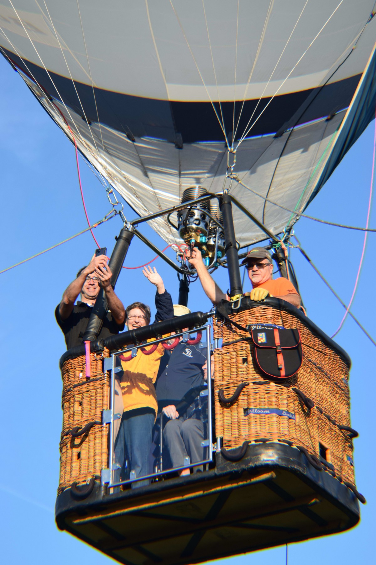 A group of people enjoying a ride in a hot air balloon on a clear day.