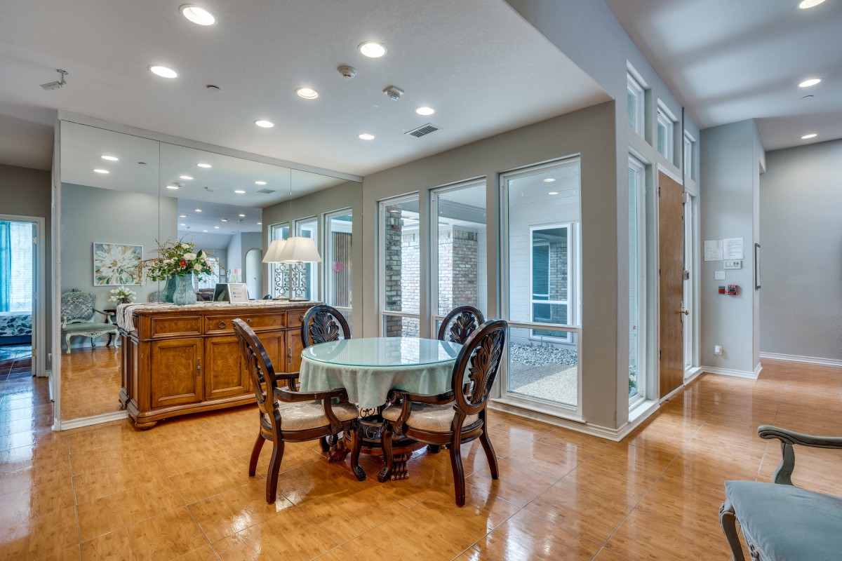 A modern dining area with elegant furniture and large windows.