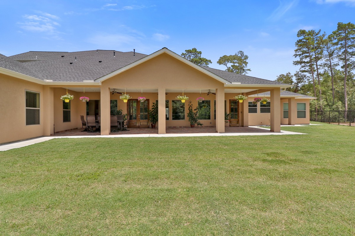 A suburban house with a large patio and manicured lawn.