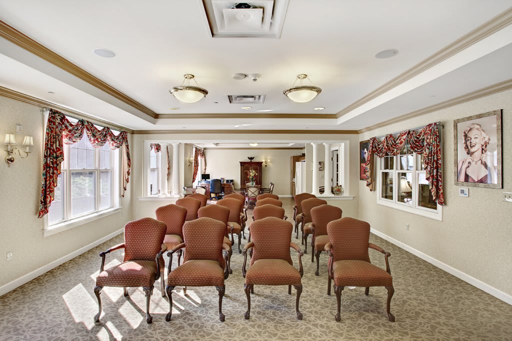 An elegantly decorated conference room with rows of chairs and large windows.