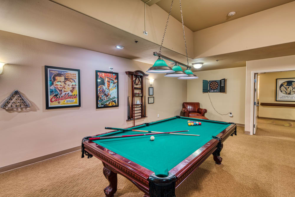 A cozy game room featuring a pool table and decorative wall posters.