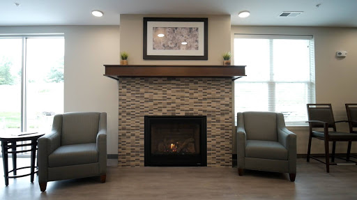 A cozy living room featuring a modern fireplace, stylish seating, and decorative elements.