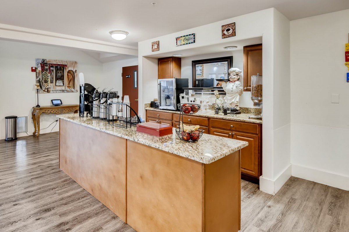 A well-equipped kitchen area with a coffee station and granite countertops.