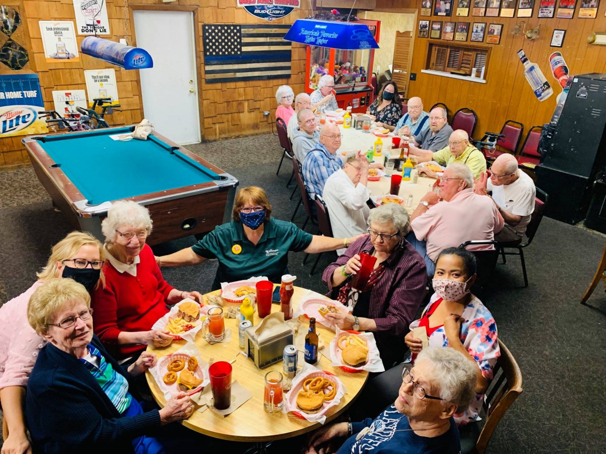 A group of elderly people enjoying a meal together in a casual setting.