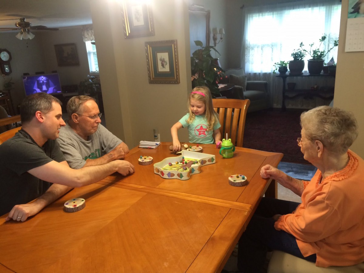 A multigenerational family playing a board game together at home.