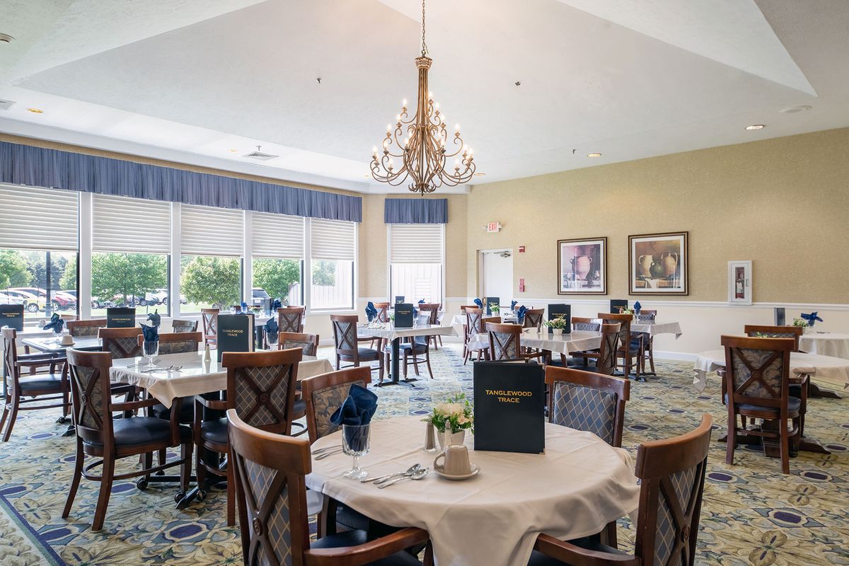 Elegant dining area with neatly arranged tables and a chandelier.
