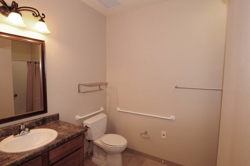 A simple bathroom with a toilet, sink, and neutral decor.