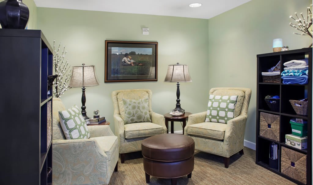 A cozy living room setup with armchairs, lamps, and a central table.
