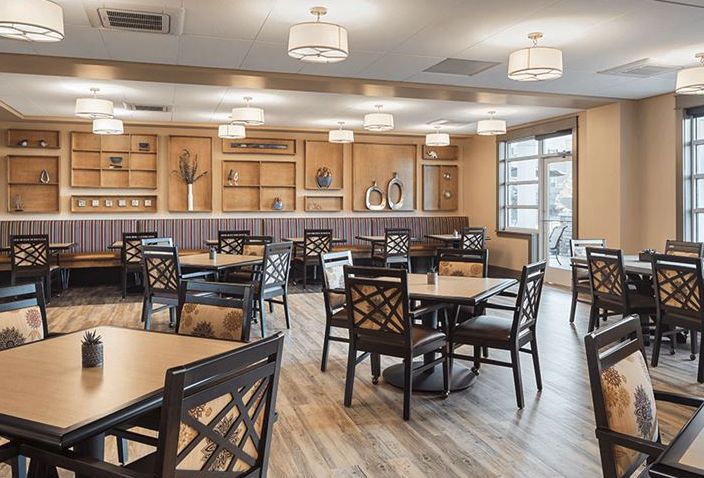 A spacious and modern dining room with neatly arranged tables and chairs.