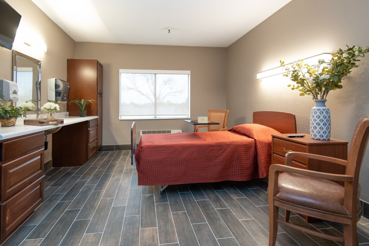 A modern and minimalistic bedroom with a single bed, chair, and window.