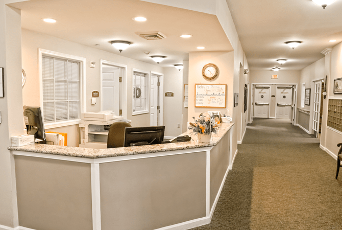 A bright and welcoming office reception area with a desk and corridor.