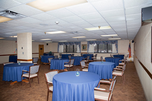 A spacious dining area set up with blue tablecloths and chairs, ready for an event.