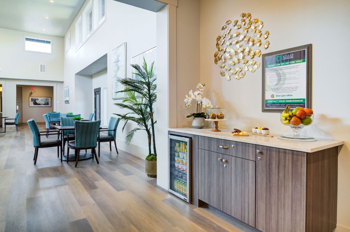 A stylish modern interior featuring a dining area with wooden flooring, decorative plants, and contemporary artwork.
