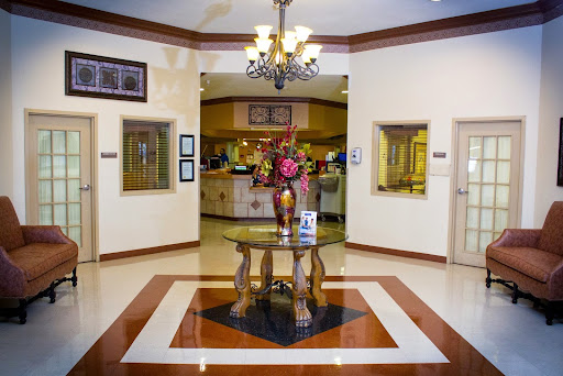 A welcoming hotel lobby featuring elegant decor and a vibrant floral arrangement.