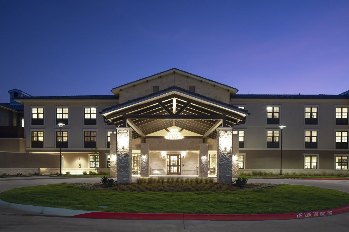 A hotel entrance illuminated at night.