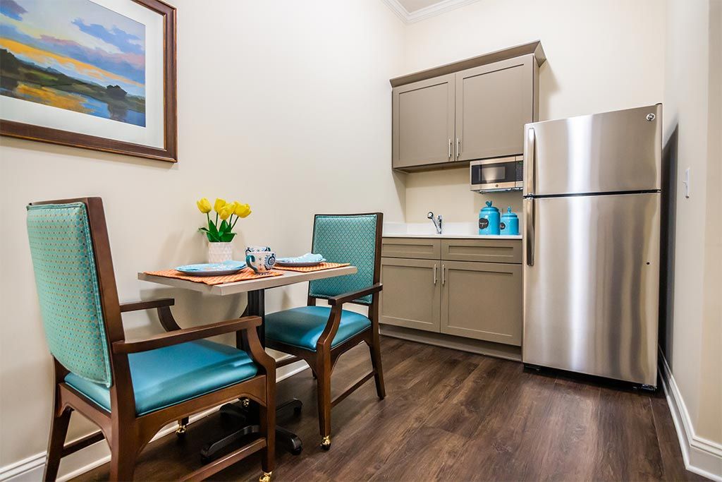 A cozy kitchenette with a small dining area, featuring modern appliances and decor.