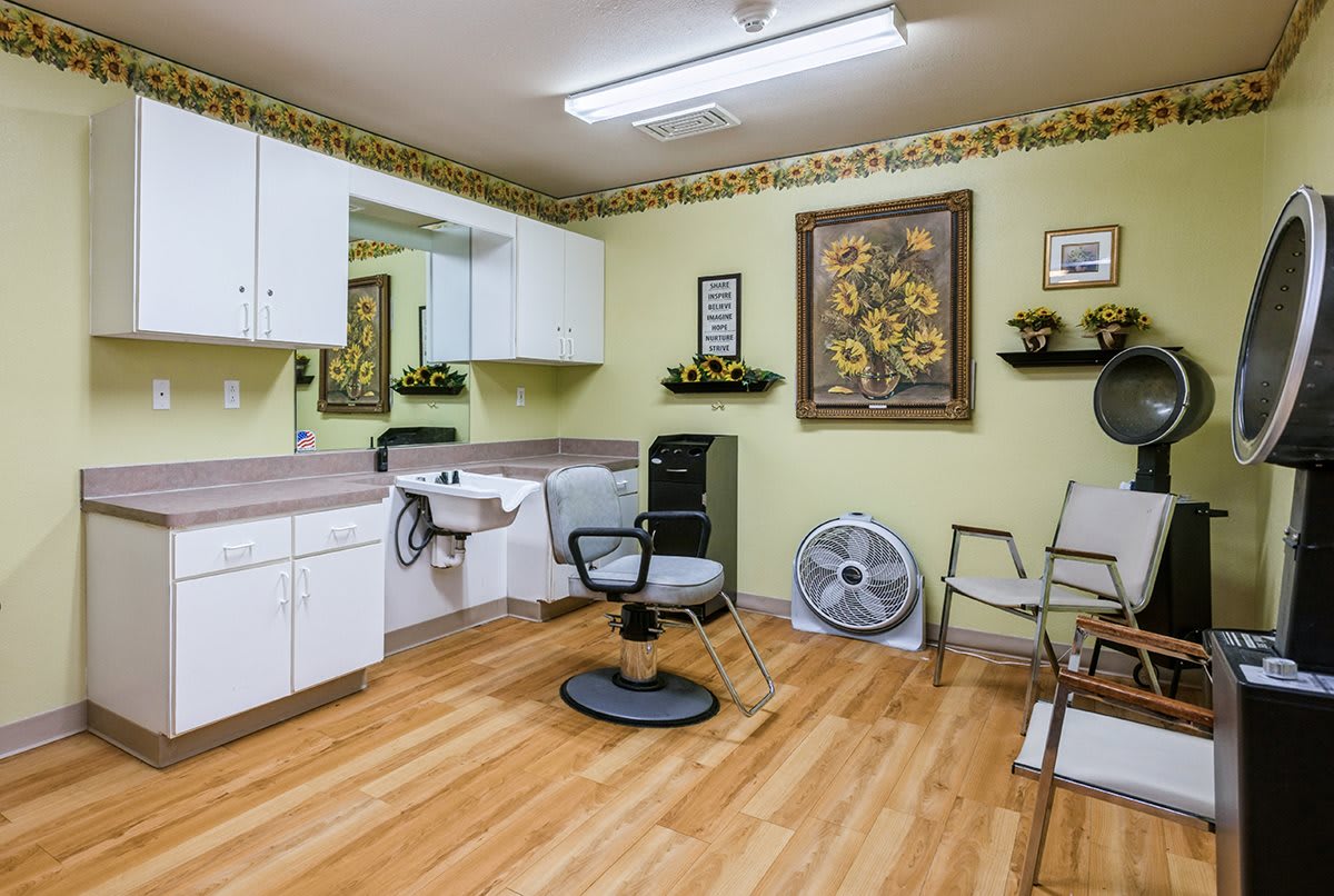 A well-equipped hair salon with a central chair, mirror, and stylish wall decorations.