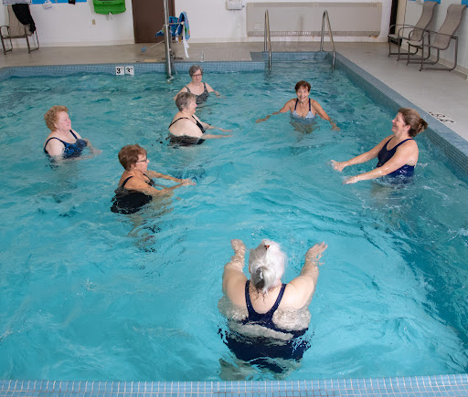 A group of women participating in an aquatic exercise class in a swimming pool.