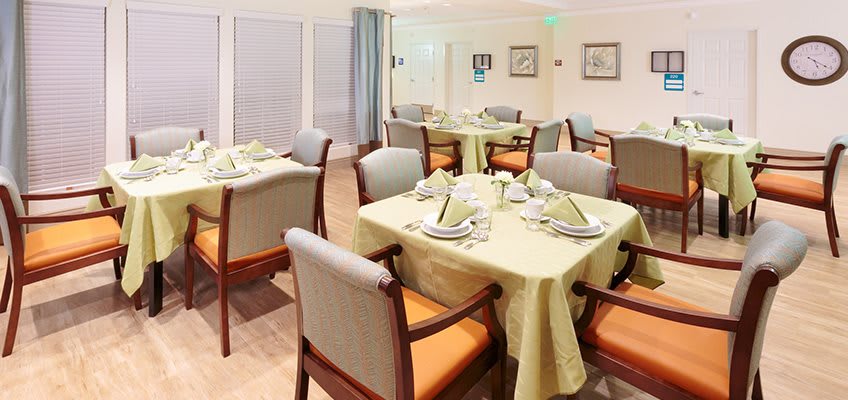 An elegantly set dining room with neatly arranged tables and chairs.