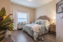 A cozy bedroom with light blue bedding and a large window.