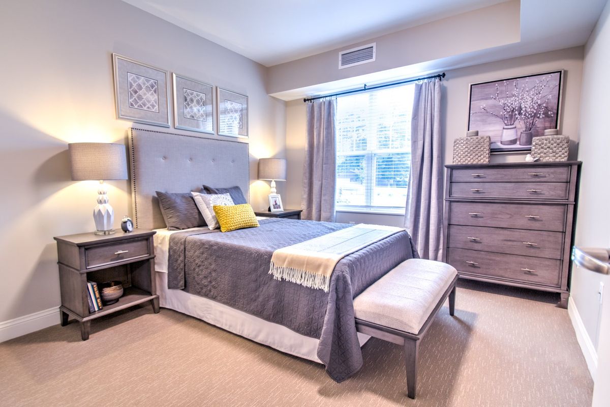 A modern and cozy bedroom with stylish decor, featuring a comfortable bed, matching furniture, and soft lighting.