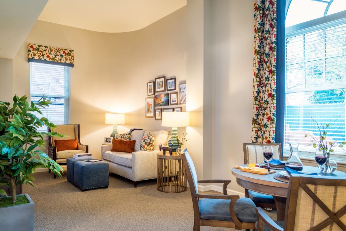 A cozy living room featuring a white sofa, colorful curtains, and warm lighting.