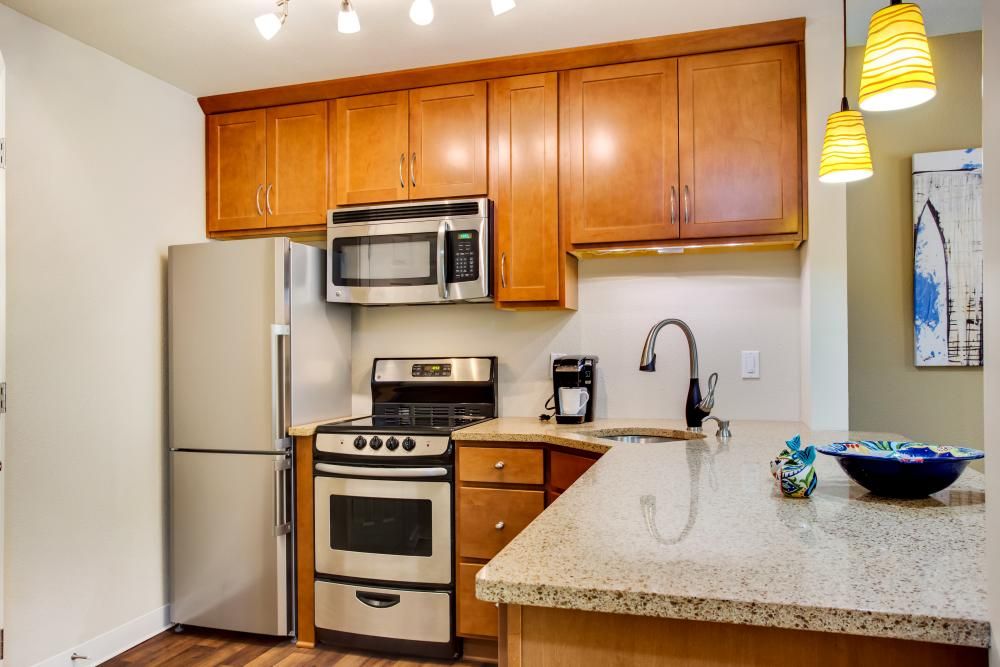 Modern kitchen with stainless steel appliances and wooden cabinets.