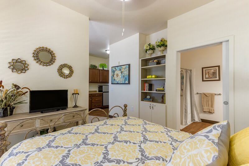 Cozy living room with a stylish decor featuring a television, bookshelf, and decorative elements.