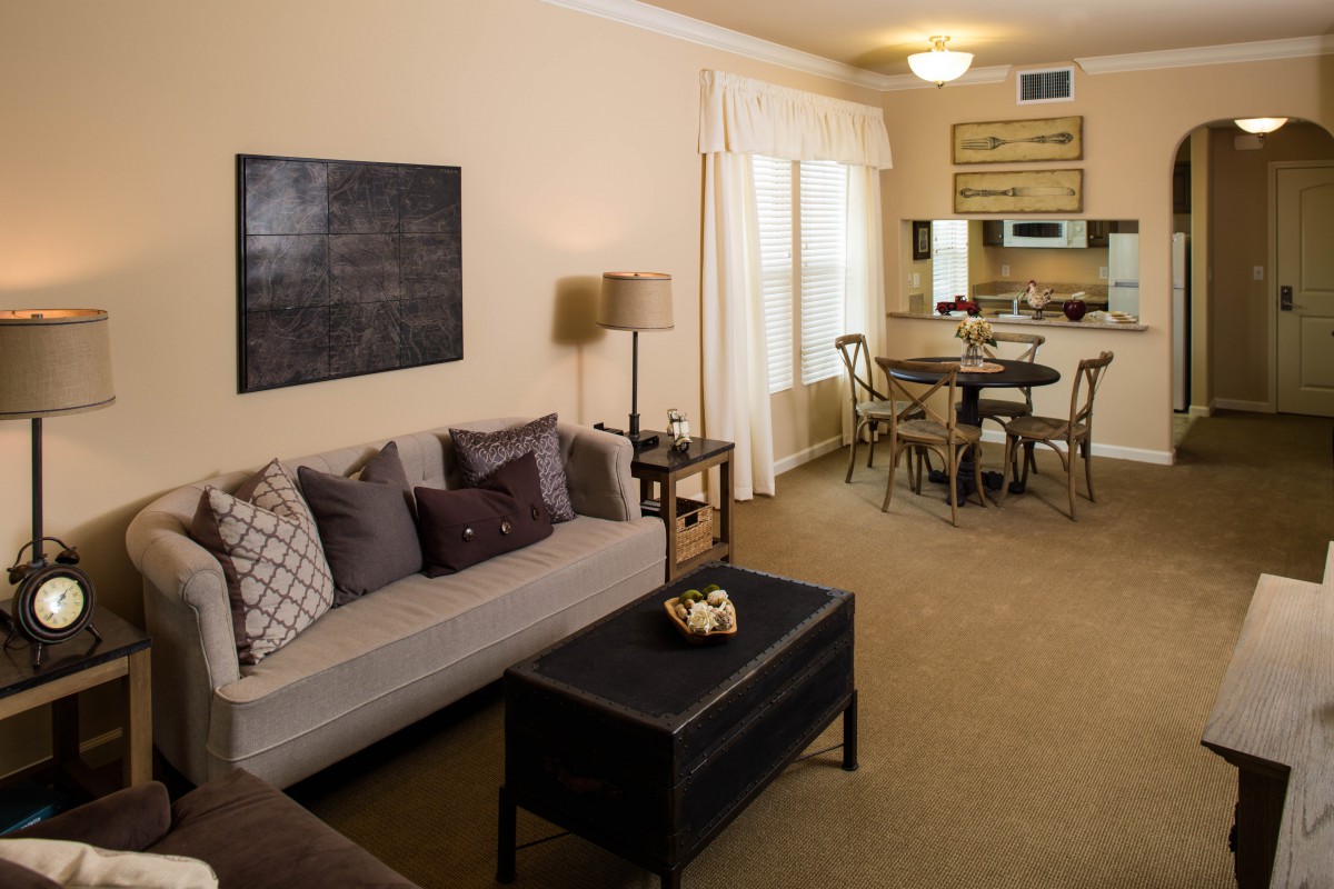 A cozy living room with a comfortable sofa, coffee table, and adjacent dining area.