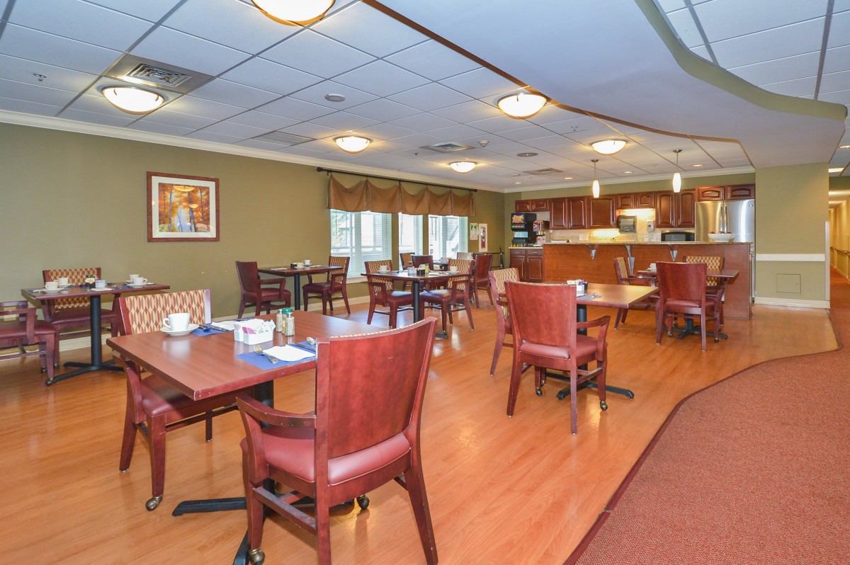 A spacious and well-lit dining area with wooden furniture and a warm, inviting atmosphere.