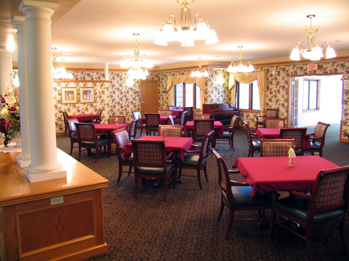 An elegantly decorated dining room with red tablecloths and stylish chairs.