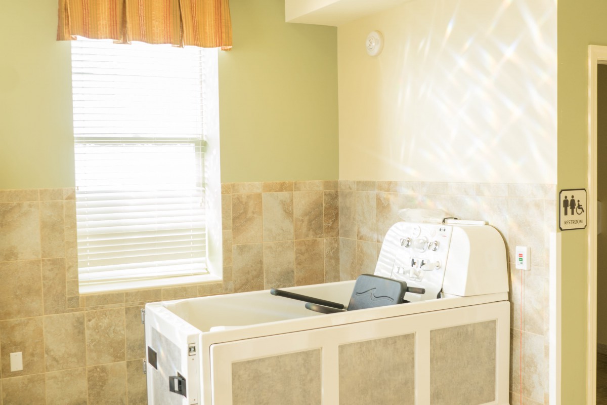 A sterile morgue room featuring an autopsy table and tiled walls.