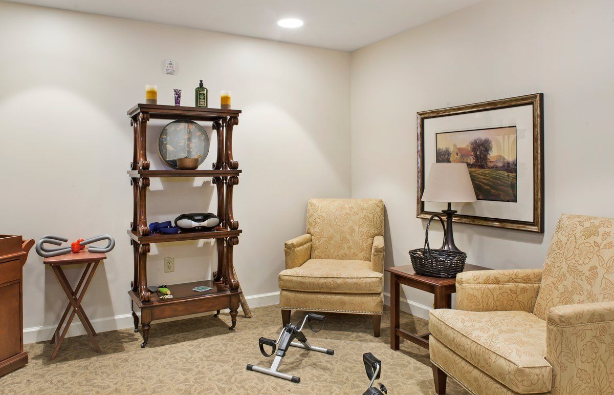 Cozy living room with armchairs and a decorative shelf.