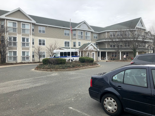 A view of a residential building with a parked van in the foreground.