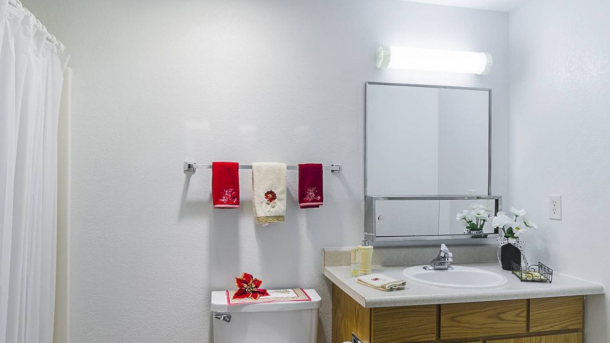 A neatly organized bathroom with colorful towels and a clean sink area.