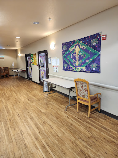 A well-lit hallway featuring decorated walls, with tables and chairs arranged alongside.