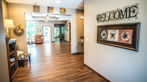 A warm and inviting lobby with modern decor and wooden flooring, featuring a welcoming sign.