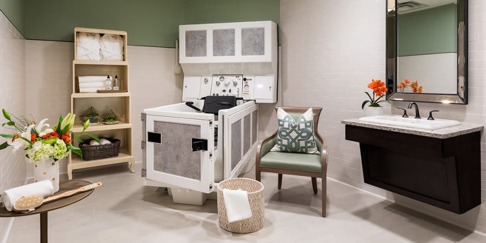 A serene therapy room featuring a specialized massage bed, cozy chair, and calming decor.