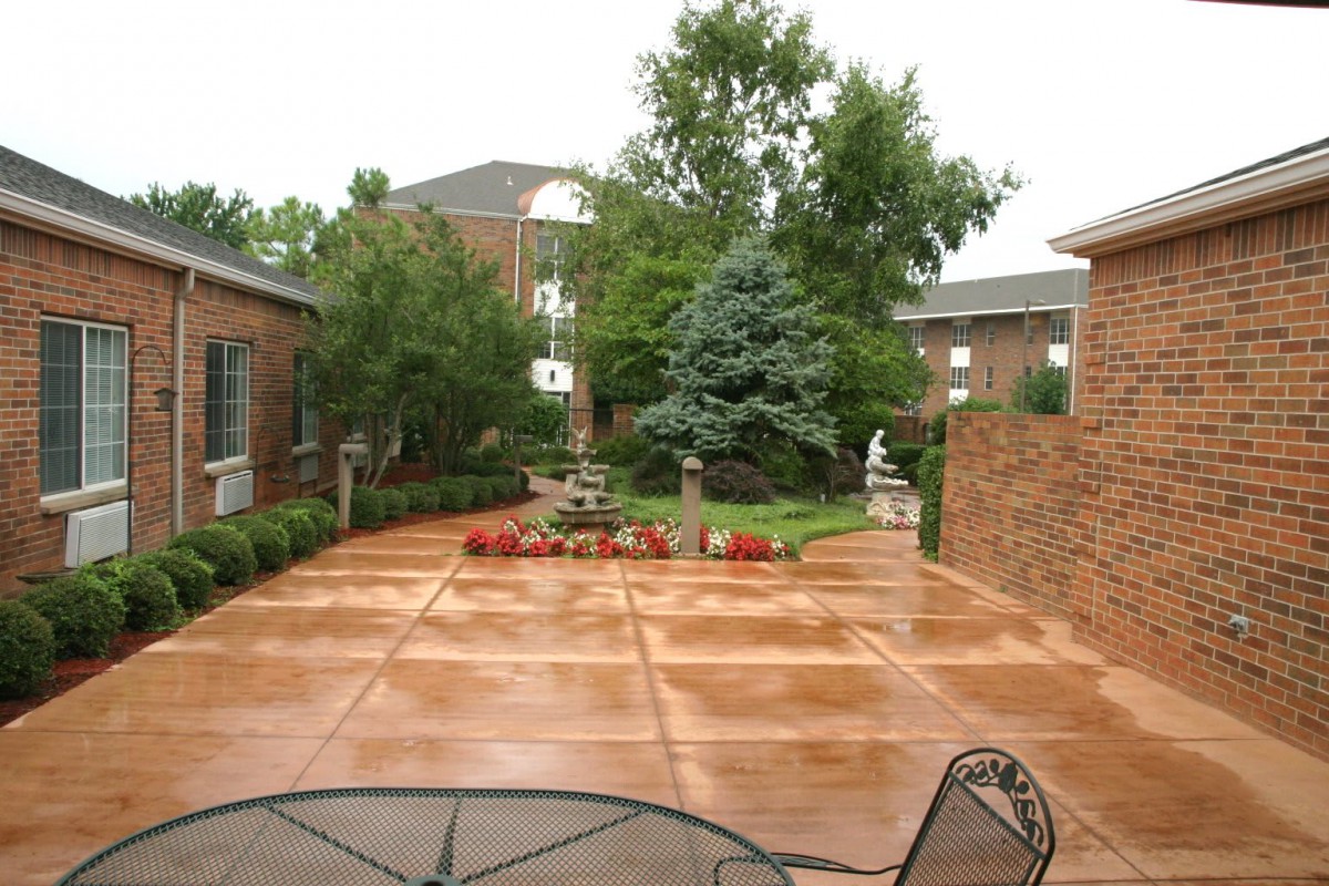 A serene courtyard with a well-maintained garden and patio area surrounded by buildings.
