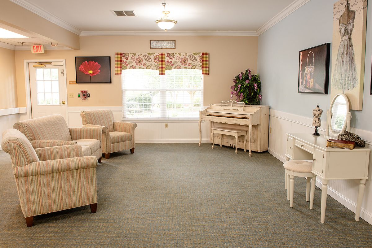 A cozy living room with a piano and comfortable seating.