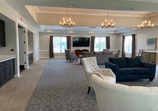 Spacious living room with comfortable seating and elegant chandeliers.