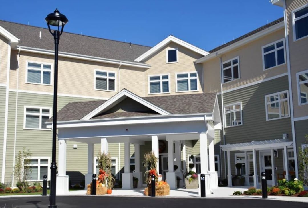 A residential building with a covered entrance and decorative planters.