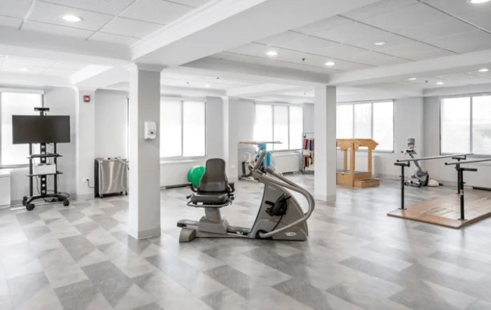 A modern, well-lit gym featuring various exercise equipment.