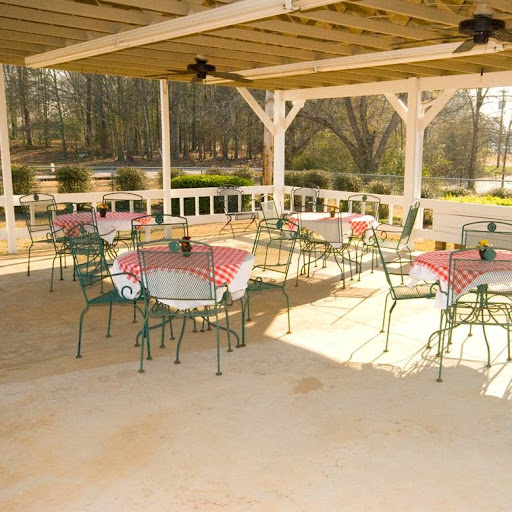 A tranquil outdoor dining area with tables set for guests, surrounded by nature.