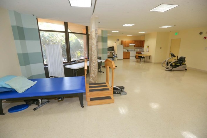 A rehabilitation therapy room equipped with exercise stairs and therapy tables.