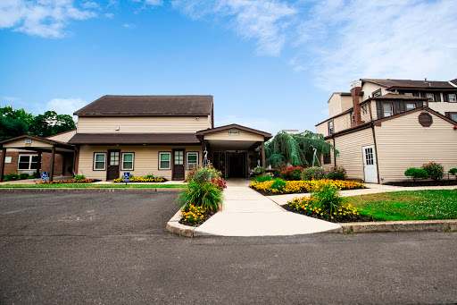 A welcoming entrance with beautifully landscaped gardens and a clear blue sky.